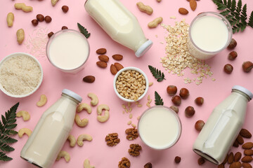 Obraz na płótnie Canvas Different vegan milks and ingredients on pink background, flat lay