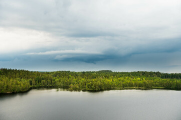Fototapeta na wymiar Storm with dark rain clouds over the Swedish forest and lakes at the Aboda Klint viewpoint in Högsby