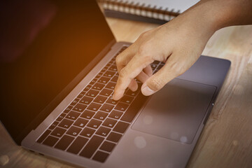 Fototapeta premium Fingers touch keyboard concept, Closeup photo of male hands with laptop, Man working remotely at home.