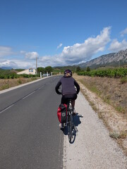 jeune femme à vélo qui randonne en itinérant à bicyclette dans le sud de la France