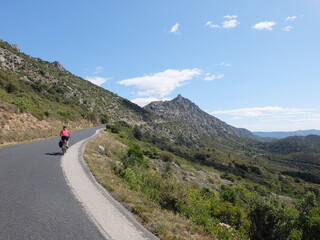Naklejka premium jeune femme à vélo qui randonne en itinérant à bicyclette dans le sud de la France