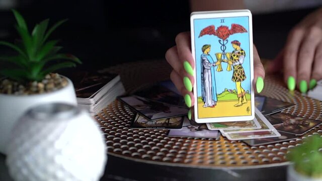 Fortune teller woman showing two of cups, reading a future by tarot cards. Esoteric concept, fortune telling and predictions