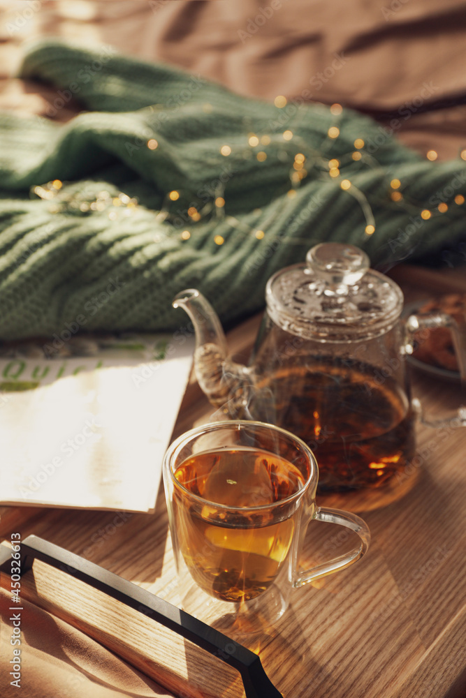 Poster Wooden tray with freshly brewed tea on bed in room. Cozy home atmosphere