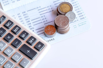 Book bank saving deposit account isolated on white background. Saving account bookbank statement calculator and thai currency coins. Financial bookkeeping, Accountancy Concept. Top view.