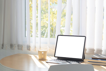 Laptop computer or tablet with white blank screen on wood desk. Workspace, workplace, desktop office concept.