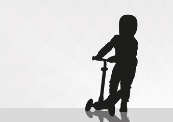A small child boy rides a skateboard. A shadow