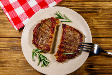 Grilled pork steaks with rosemary on wooden table. Top view