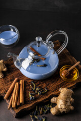 selective focus, freshly brewed blue masala tea in a transparent teapot, with fruits and fresh...