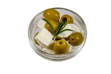 Feta cheese cubes with green olives and rosemary in glass bowl isolated on white background