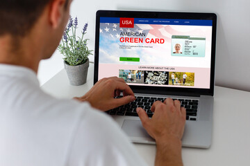 man with laptop with United States Permanent Resident Card website