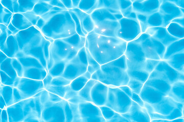 Blue water in the pool glows under the rays of the sun. Close-up