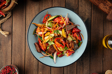 Chinese warm beef salad with vegetables and sesame seeds