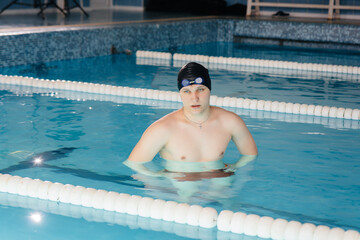 A young athlete trains and prepares for swimming competitions in the pool. Healthy lifestyle.