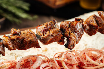 Closeup on grilled georgian lamb meat shashlik skewers with onion