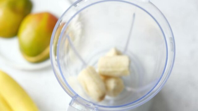 Process of preparing mango banana smoothie. Add ingredients into electric blender cup