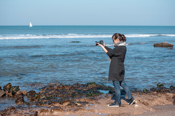 woman photographer taking a photo at the beach	
