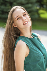 Close up portrait of a young beautiful girl in summer park