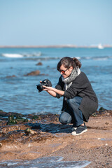 woman photographer taking a photo at the beach	
