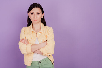 Portrait of confident business woman crossed hands look camera on violet background
