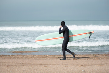 surfer walking on the beach