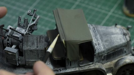 Scale Modeling. A man make Weathering on the roof of the cab. 1:35 Model of German 8ton Semi Track. Close up. 