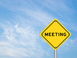 Yellow color transportation sign with word meeting on blue sky background