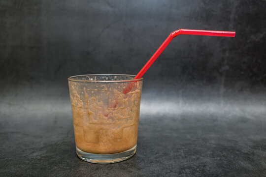 Empty Glass With Chocolate-flavored Milkshake Straw