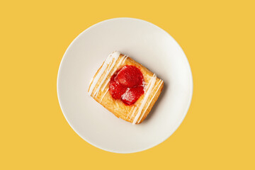 Puff pastry patties with strawberries on a plate. Puff pastry filled. Yellow background.