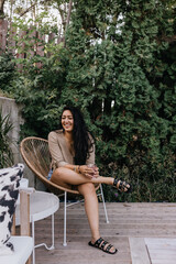 Young adult filipino woman sitting outside relaxing on patio