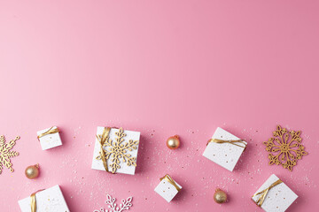 Christmas decorations with packaging gifts and balls on pink background. Flat lay, copy space