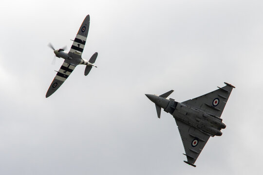 World War Two Spitfire fighter in formation with an RAF Typhoon. The Typhoon carries special anniversary markings/