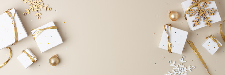 Christmas decorations with packaging gifts and balls on pastel beige background. Flat lay, copy space