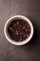 selective focus, natural black leaf tea. brewing in a clay bowl. vertical angle, macro. on a dark background. for menus and cafes