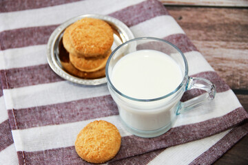 white milk in a glass mug and shortbread cookies
