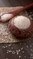 Sugar in glass bowl on wooden background.