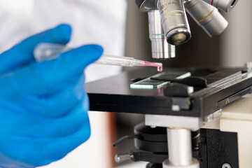 a professional scientist or researcher holding a test tube The pipette lowers the sample into the test tube. by virus analysis Corona COVID-19 in the near term scientific laboratory test