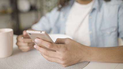 Black teen girl texting on smartphone during breakfast, gadget addiction