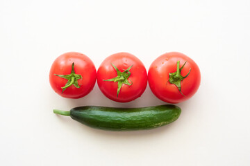 Three ripe tomatoes and one green cucumber