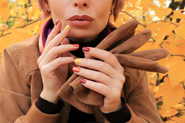 A model with accessories and a multi-colored manicure in autumn.