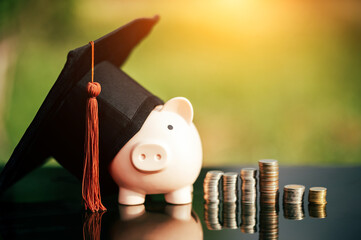 piggy bank With Graduation Cap on black glass floor,Money saving concept.. - obrazy, fototapety, plakaty