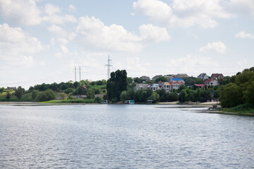 Fototapeta premium Reeds along banks of river with river houses docked on the opposite side reflecting in still waters. Weekend by the river. Fishing lake