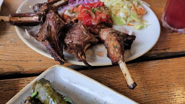 Stuffed Greek Wine Grape Leaves (dolmades) with Roasted Lamb Chops Ribs with spices, vegetables. Selective focus