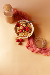 Fototapeta na wymiar Cereals in apricot bowl with fresh strawberry for breakfast on soft linen background