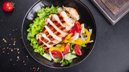 salad grilled chicken breast vegetables tomato, cucumber, onion, pepper outdoor meal snack on the table copy space food background rustic. top view keto or paleo diet