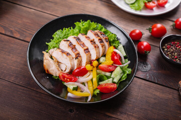 salad grilled chicken breast vegetables tomato, cucumber, onion, pepper outdoor meal snack on the table copy space food background rustic. top view keto or paleo diet