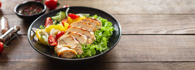 salad grilled chicken breast vegetables tomato, cucumber, onion, pepper outdoor meal snack on the table copy space food background rustic. top view keto or paleo diet