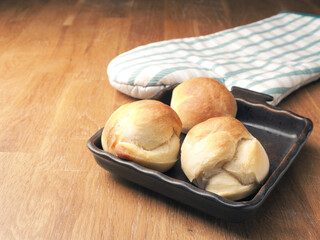 Baked yeast dough balls in a ceramic pan in a kitchen