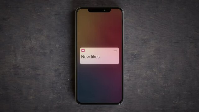 Smartphone on a desk showing new likes lockscreen notification 4k