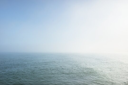 Baltic sea in a morning fog at sunrise. Soft sunlight, glowing sky, golden hour. Picturesque panoramic scenery. Nature, environment, weather, travel destinations, tourism concepts
