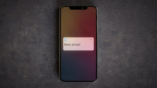 Smartphone on a desk showing new email lockscreen notification 4k